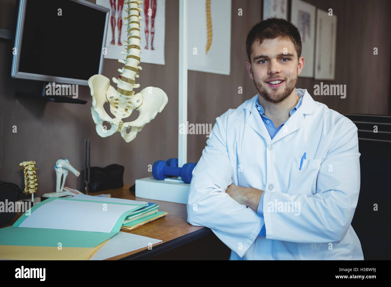 Ritratto di fisioterapista seduto alla sua scrivania Foto Stock