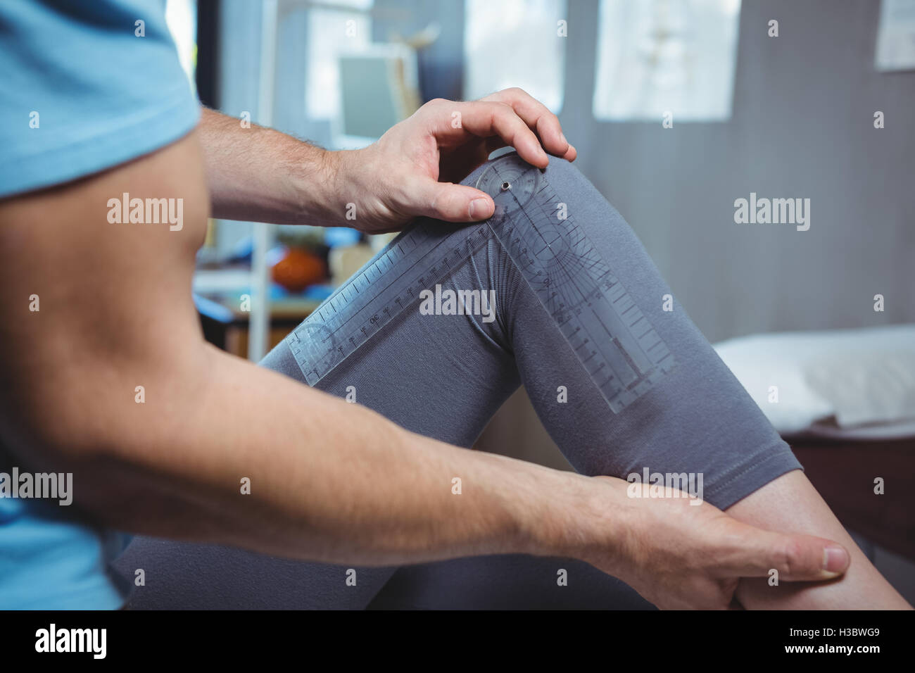 Fisioterapista esaminando femmina di ginocchio del paziente con goniometro Foto Stock