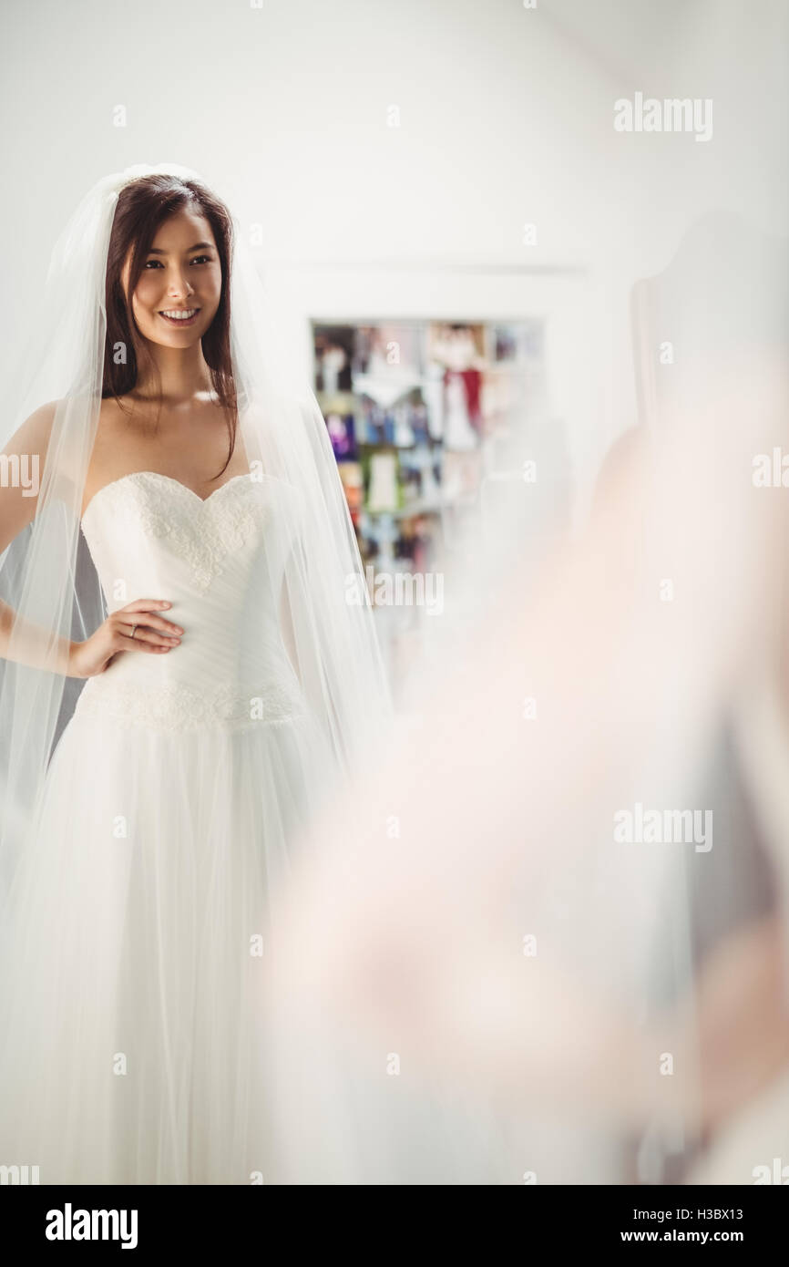 Donna cerca su abito da sposa in un negozio Foto Stock