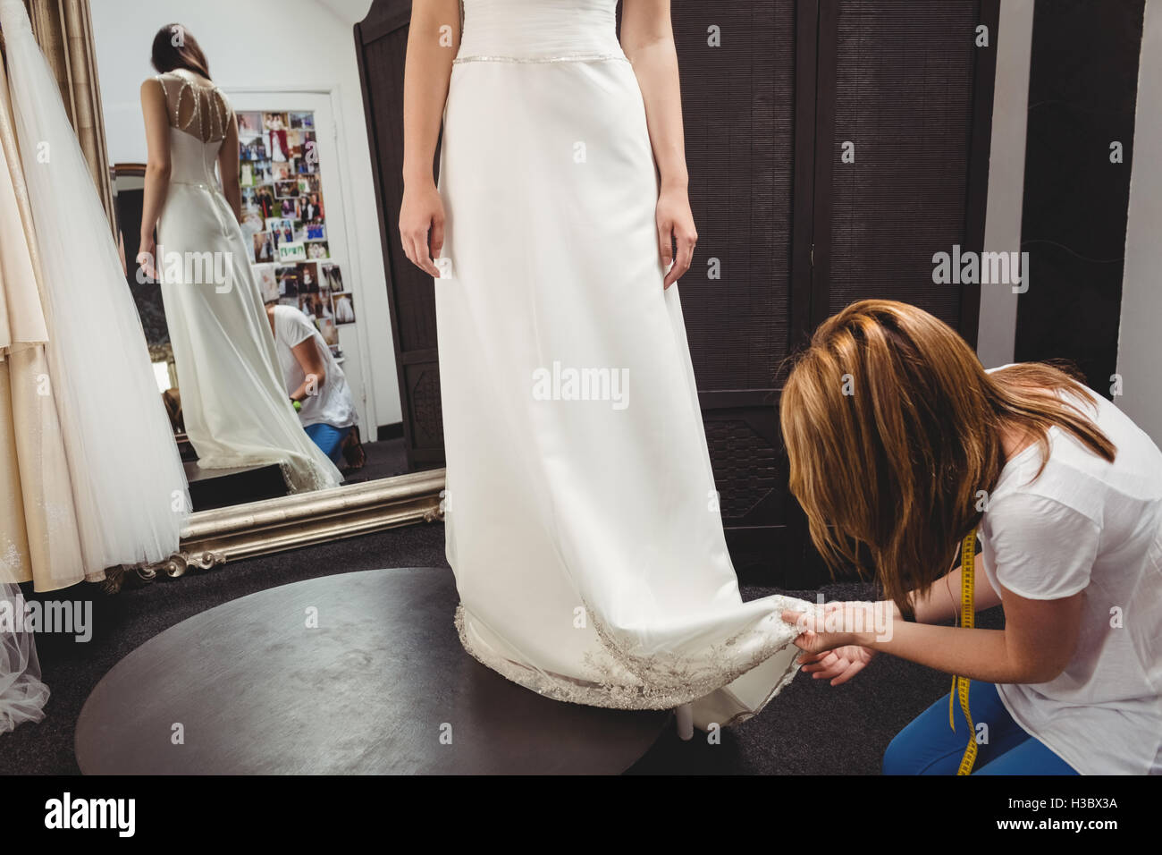 Donna cercando in abito da sposa con il contributo di designer creativo Foto Stock