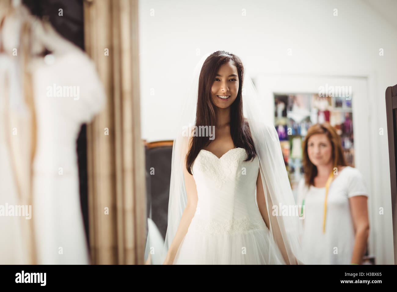 Donna cerca su abito da sposa in un negozio Foto Stock