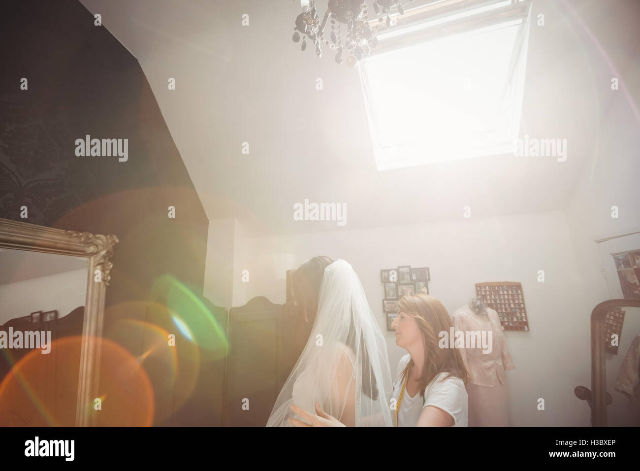 Donna cercando in abito da sposa con il contributo di designer creativo Foto Stock