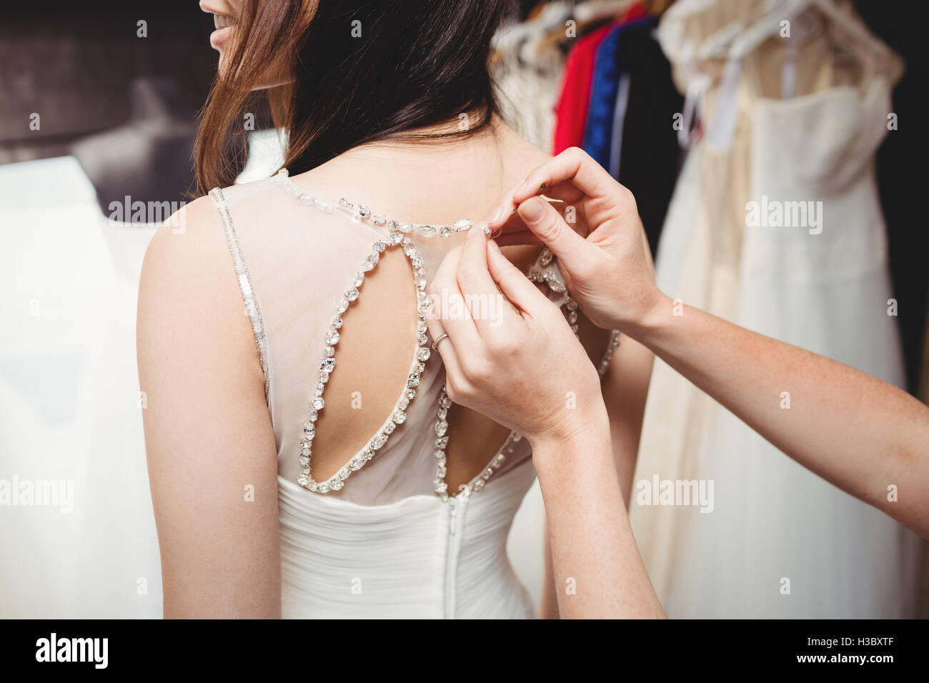 Donna cercando in abito da sposa con il contributo di designer creativo Foto Stock