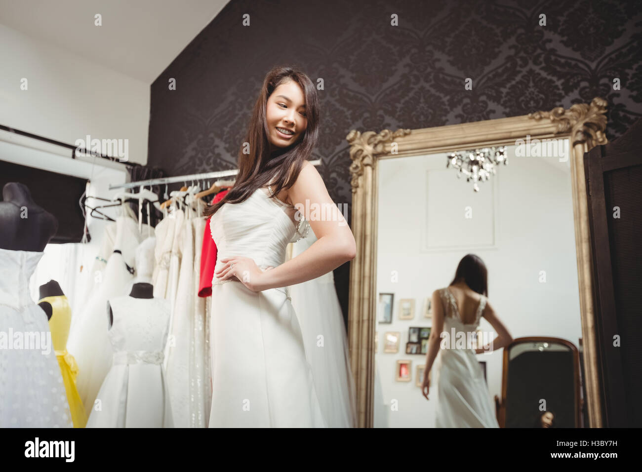 Donna cerca su abito da sposa in un negozio Foto Stock