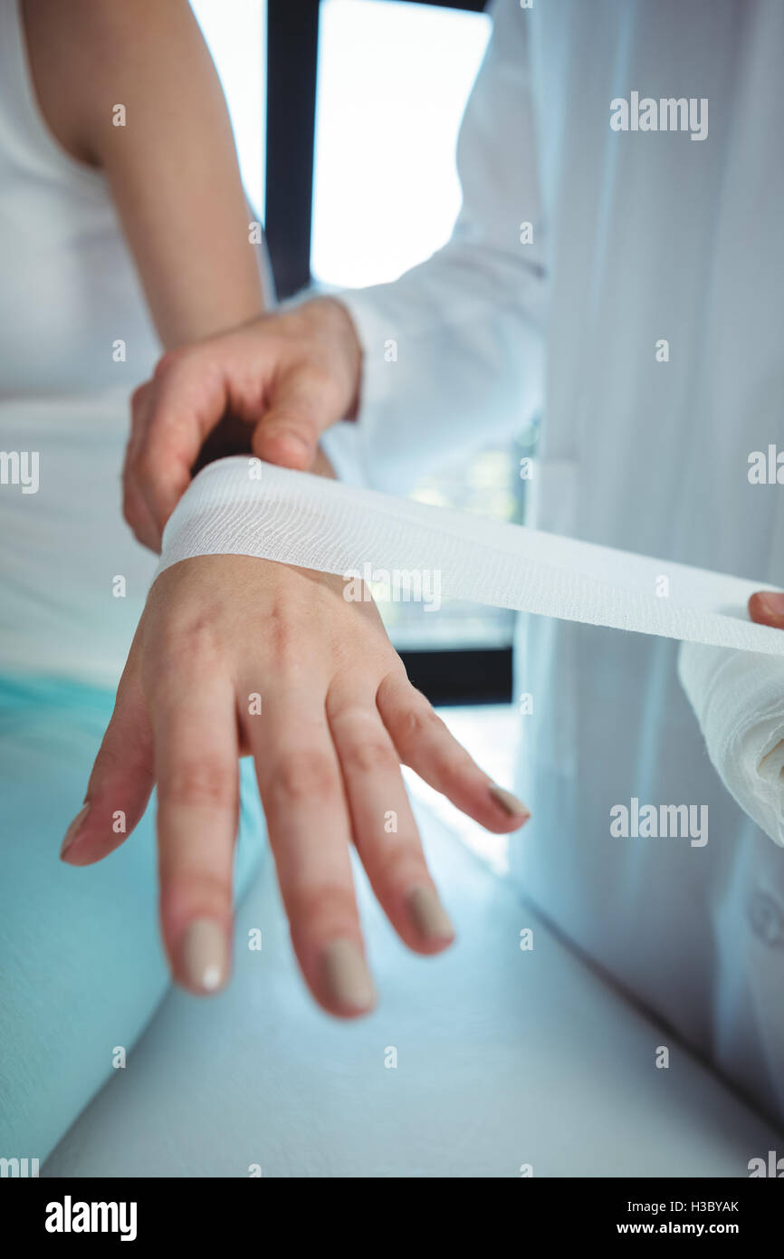Terapista del sesso maschile mettendo benda sul paziente femmina lato Foto Stock