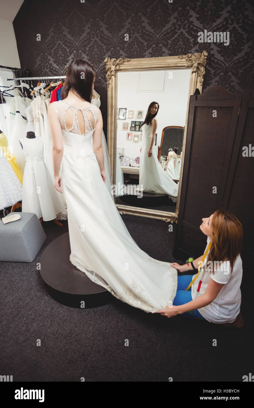 Donna cercando in abito da sposa con il contributo di designer creativo Foto Stock