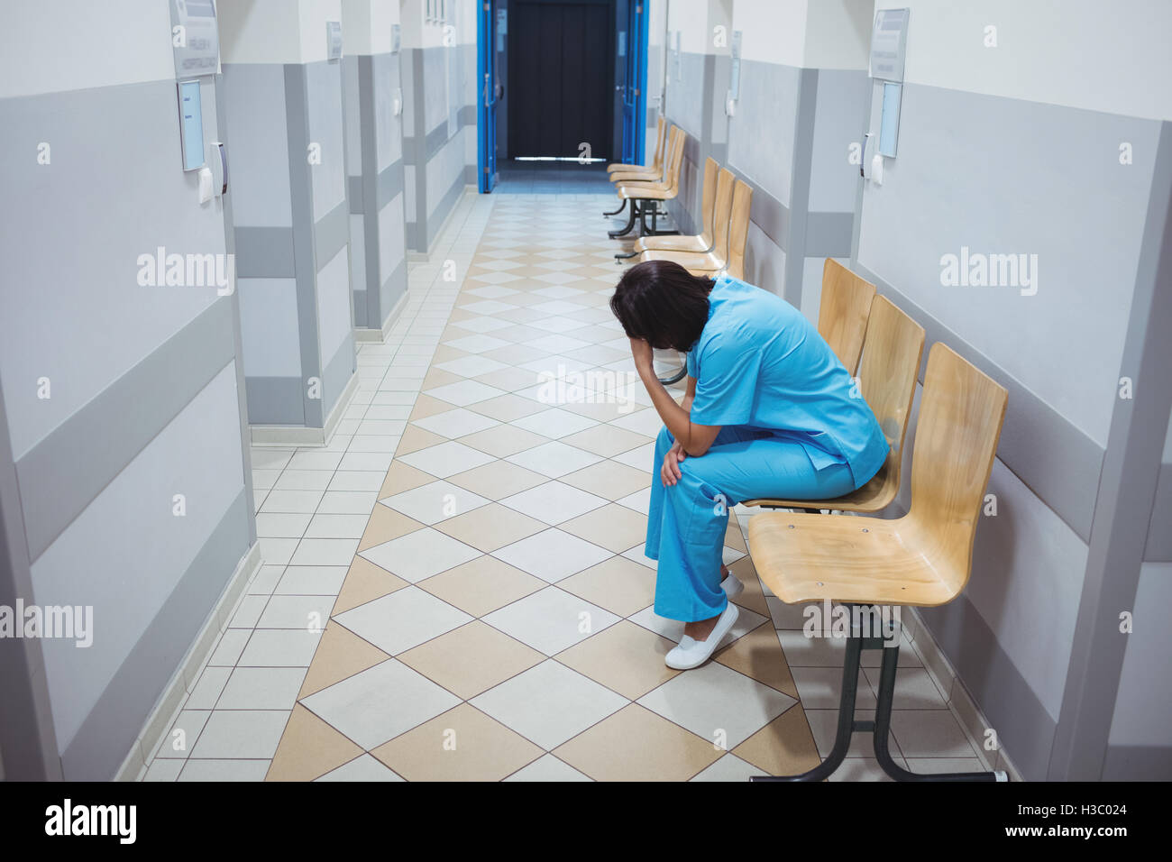 Triste infermiere seduto sulla sedia Foto Stock