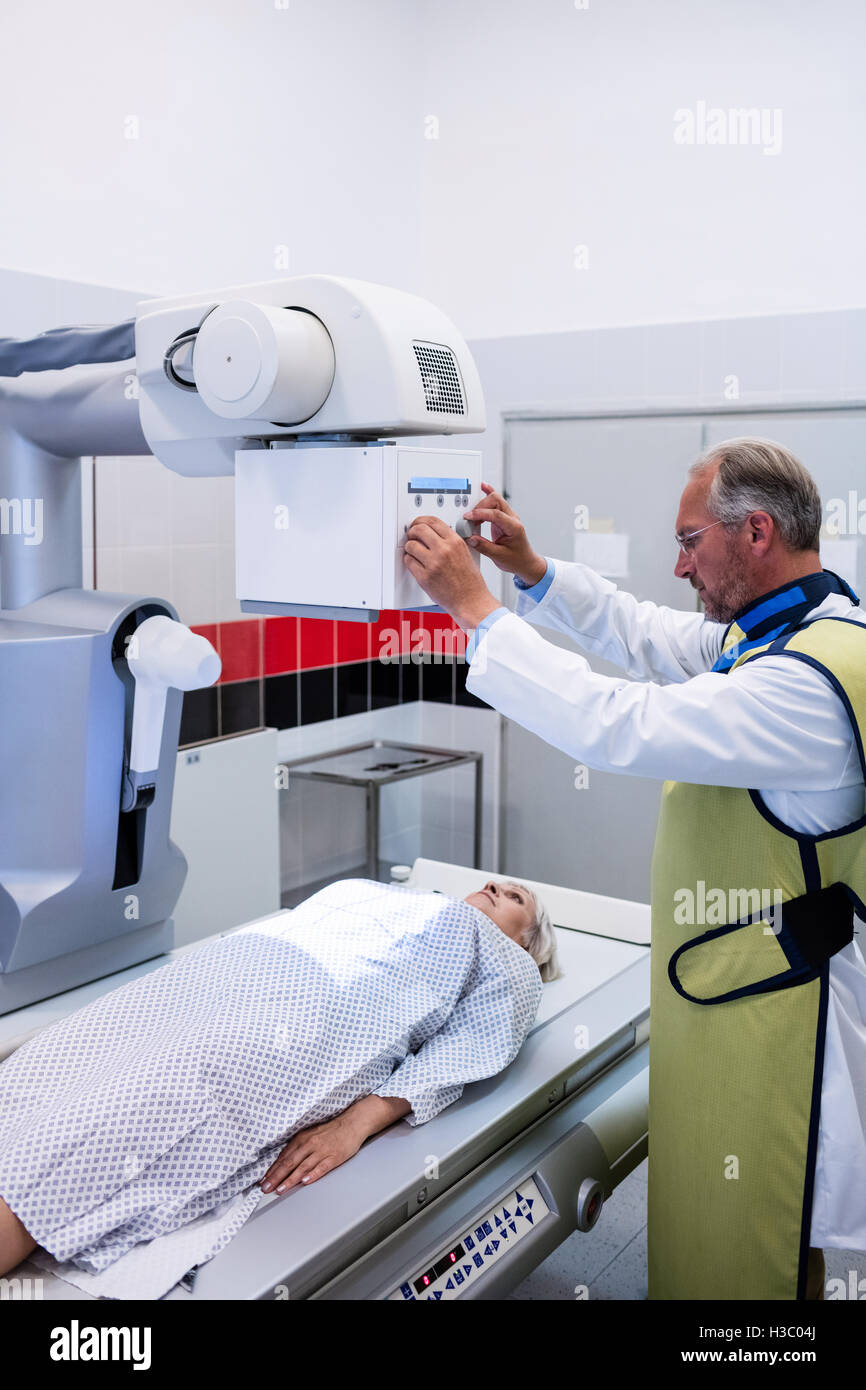 Medico usando una macchina a raggi x per esaminare il paziente Foto Stock