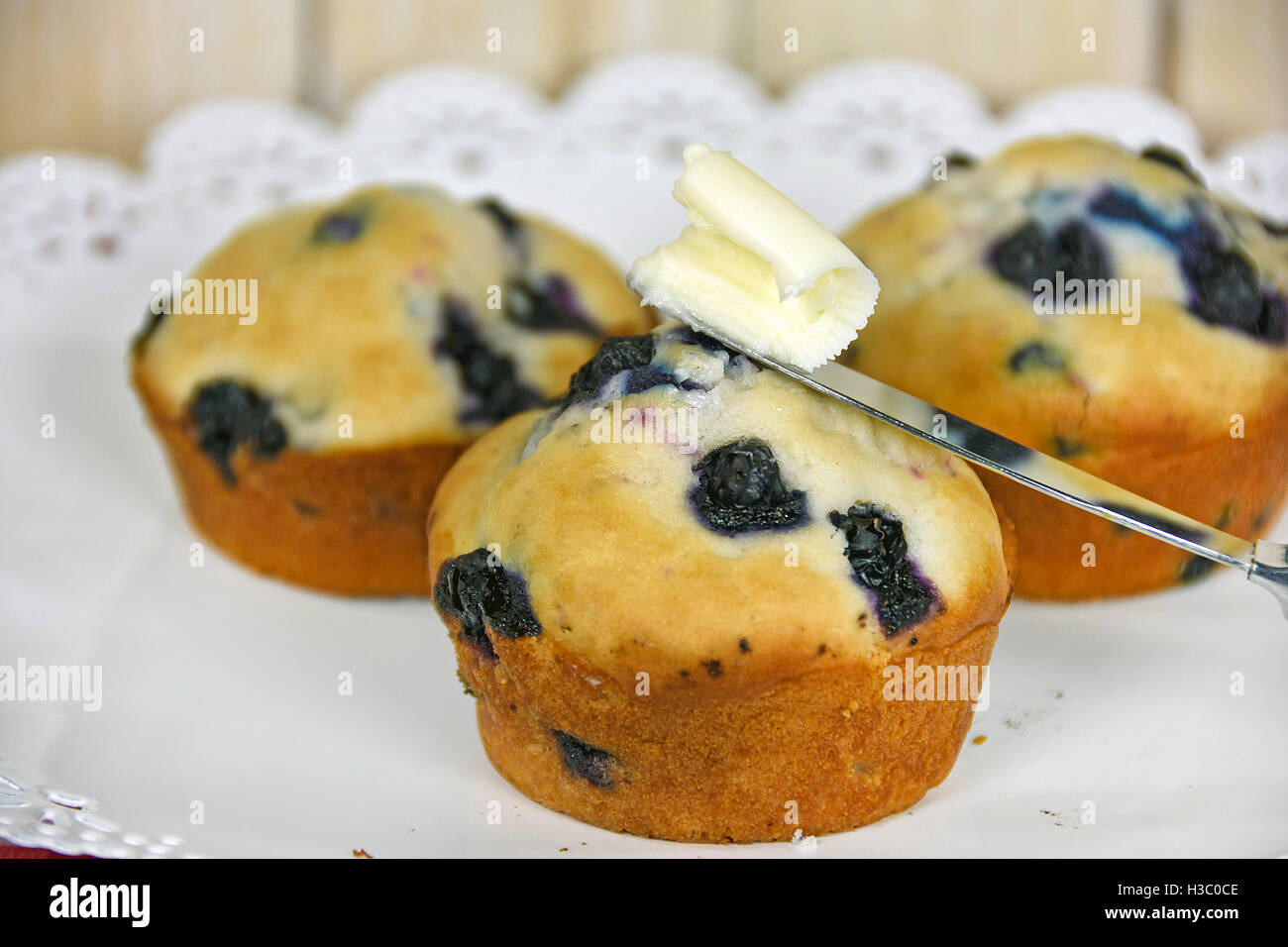 Close up in casa muffin ai mirtilli con burro sul coltello Foto Stock