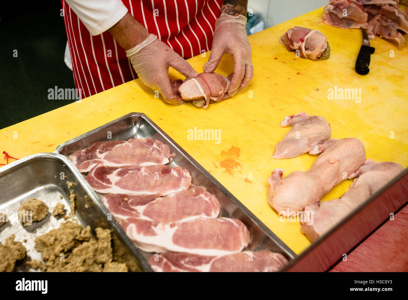 La sezione centrale del macellaio preparare un pollo e manzo roll Foto Stock