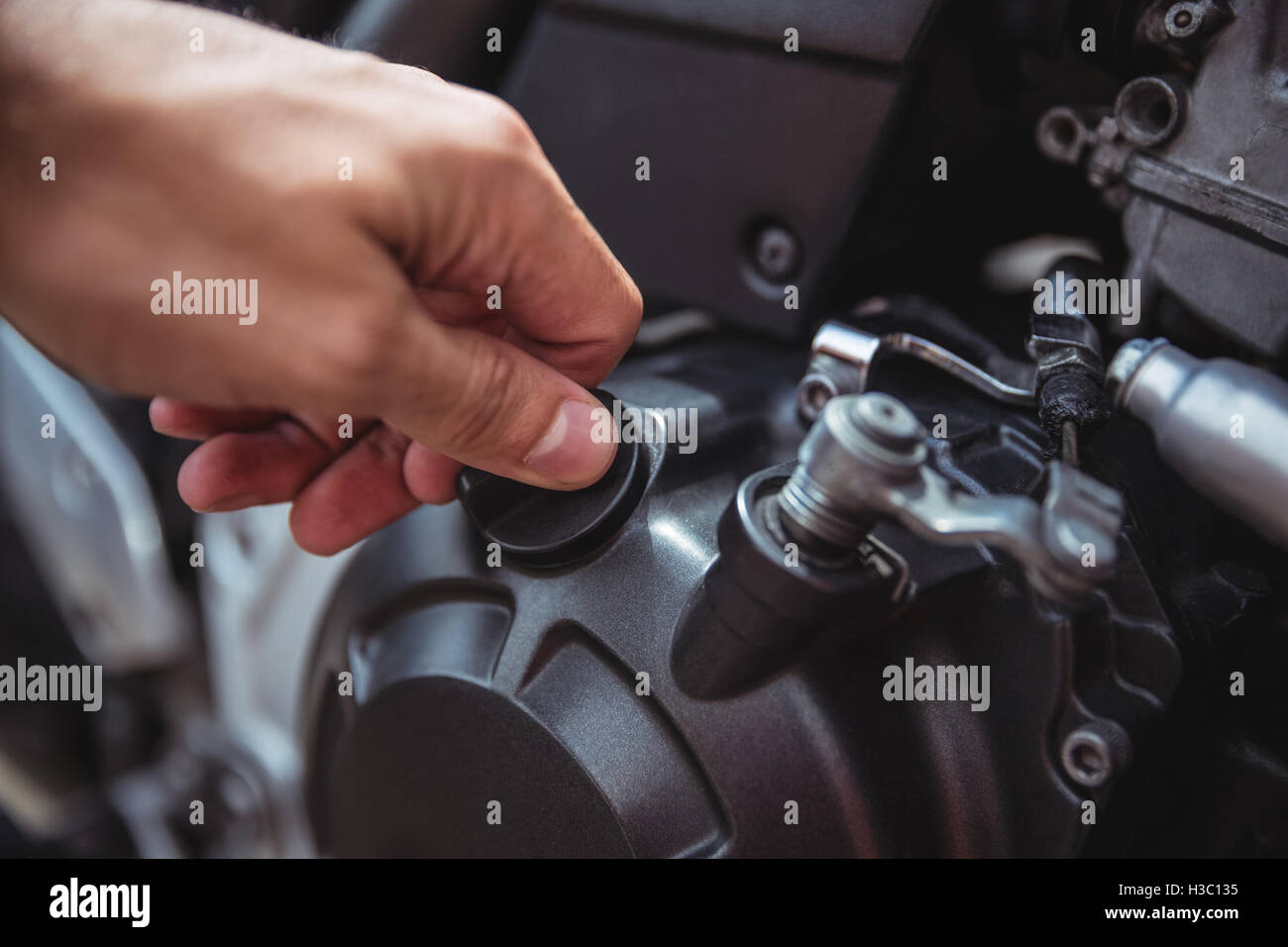 Meccanico di chiusura di un serbatoio di olio di motore bici Foto Stock