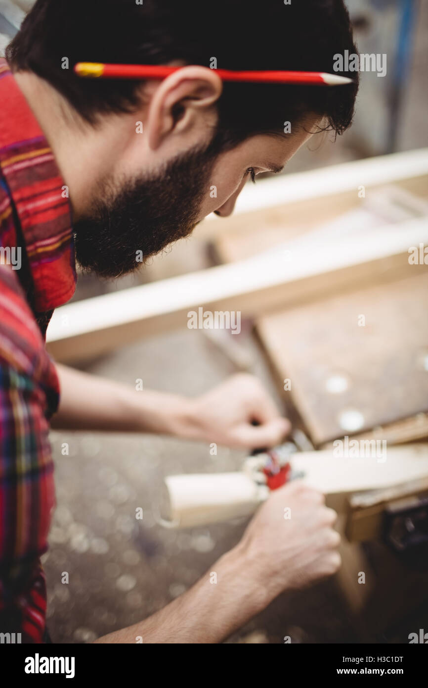 Uomo che utilizza un attrezzo portatile per rendere liscia e il livello della superficie di una tavola Foto Stock