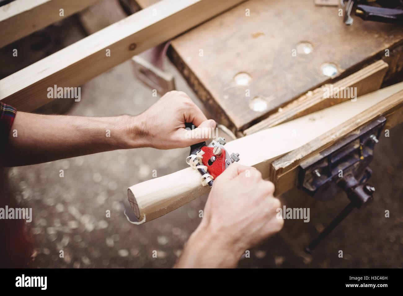 Uomo che utilizza un attrezzo portatile per rendere liscia e il livello della superficie di una tavola Foto Stock