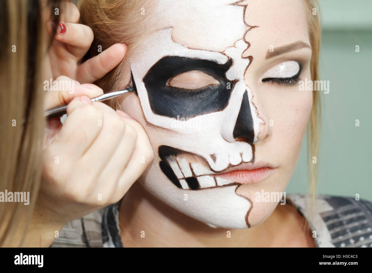 Bellissima ragazza con la faccia arte su Halloween, in bianco e nero cranio Foto Stock