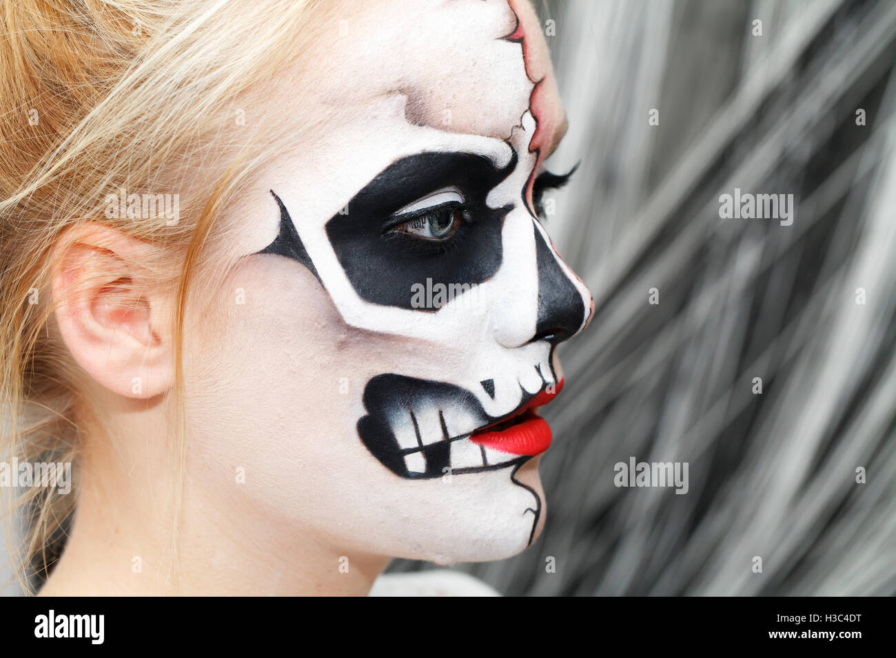 Bellissima ragazza con la faccia arte su Halloween, in bianco e nero cranio Foto Stock