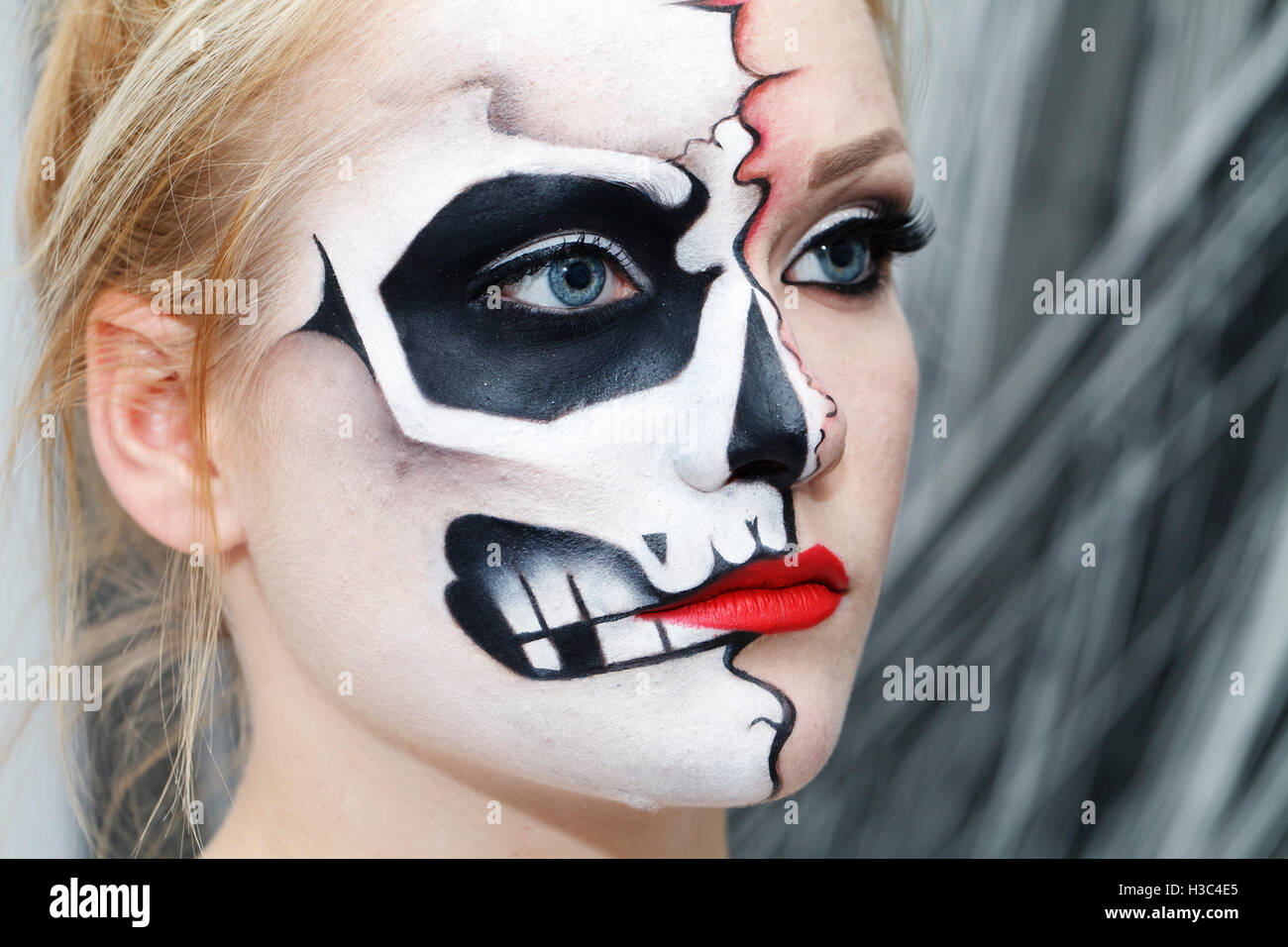 Bellissima ragazza con la faccia arte su Halloween, in bianco e nero cranio Foto Stock