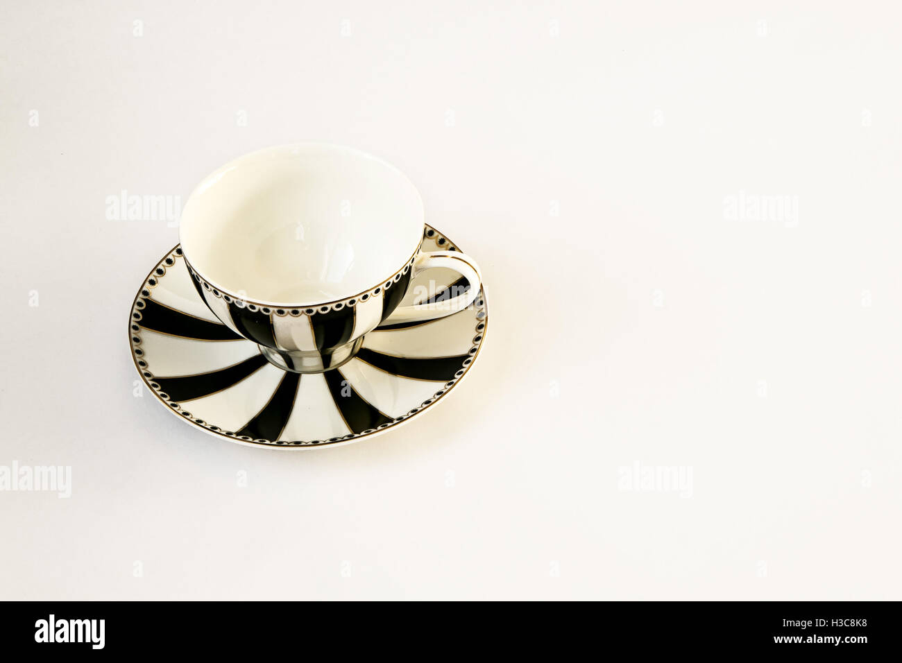 Un bel bianco e nero a strisce e coppa piattino isolato su bianco. Foto Stock