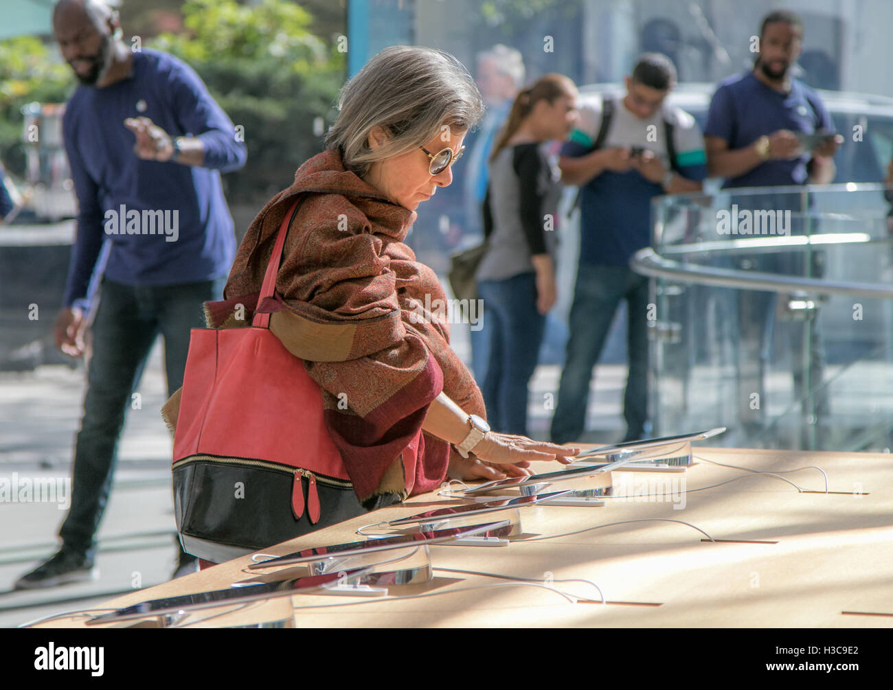 Una donna anziana sta guardando ad un tablet iPad in un Apple store sull'Upper West Side di Manhattan. Foto Stock