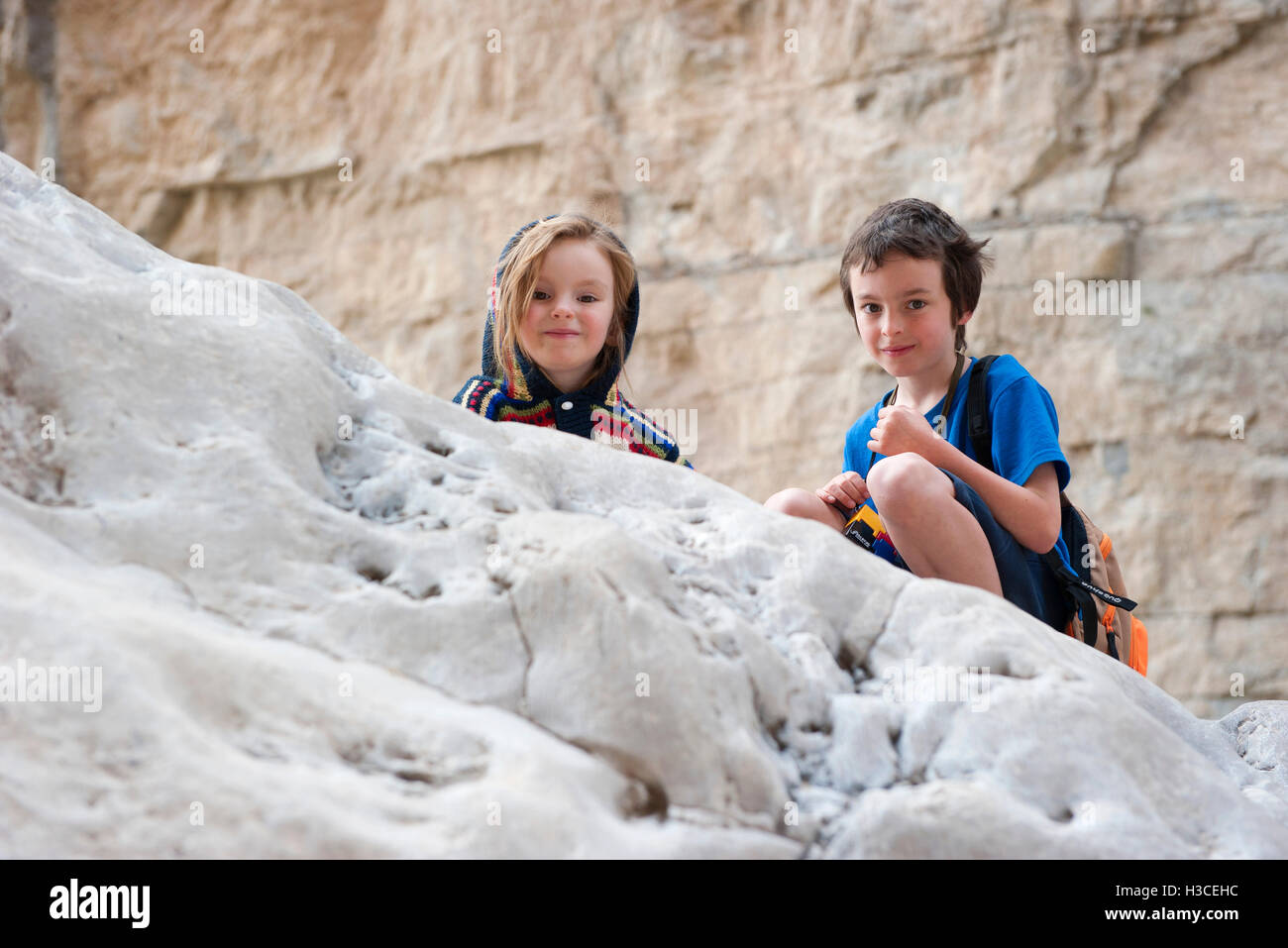 Bambini accovacciato su roccia Foto Stock