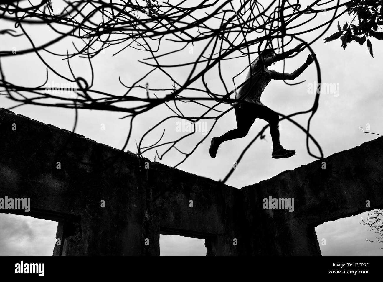 Jose Rodriguez, un freerunner da Plus Parkour team, salta sulla parte superiore delle pareti di una scuola abandonned di Bogotá, in Colombia. Foto Stock