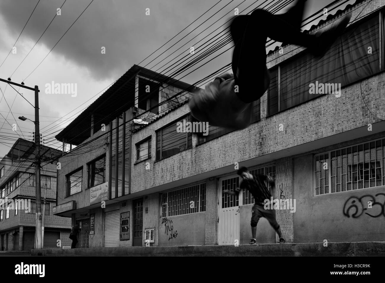Colombiano atleti parkour da Plus Parkour team a fare un front flip come si pratica su strada a Bogotà, in Colombia. Foto Stock