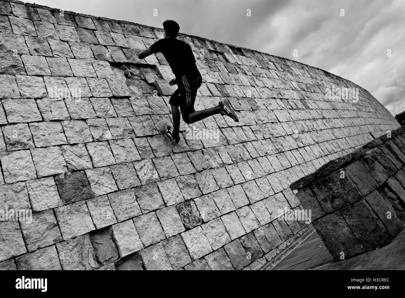 Un colombiano parkour runner salta sulla parete durante una corsa libera la sessione di formazione in un parco di Bogotá, in Colombia. Foto Stock