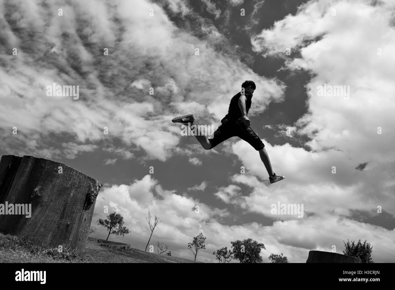 Un colombiano parkour runner esegue un salto durante un funzionamento libero esercizio di formazione in un parco a Kennedy, Bogotà, Colombia. Foto Stock