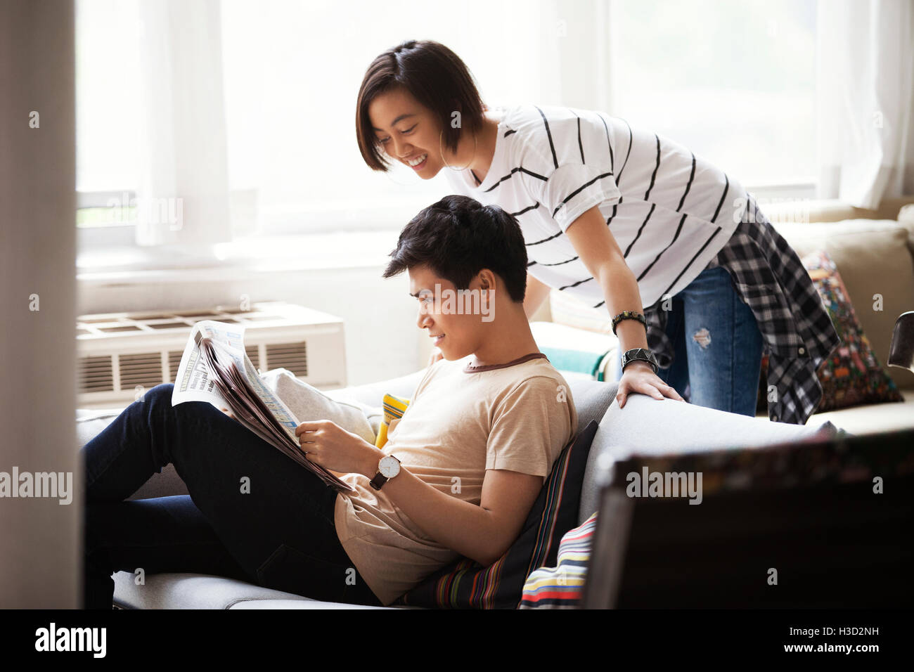 Coppia felice leggendo il giornale in soggiorno Foto Stock