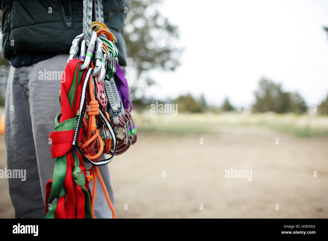 Sezione mediana di uomo che porta arrampicata attrezzature sul campo Foto Stock