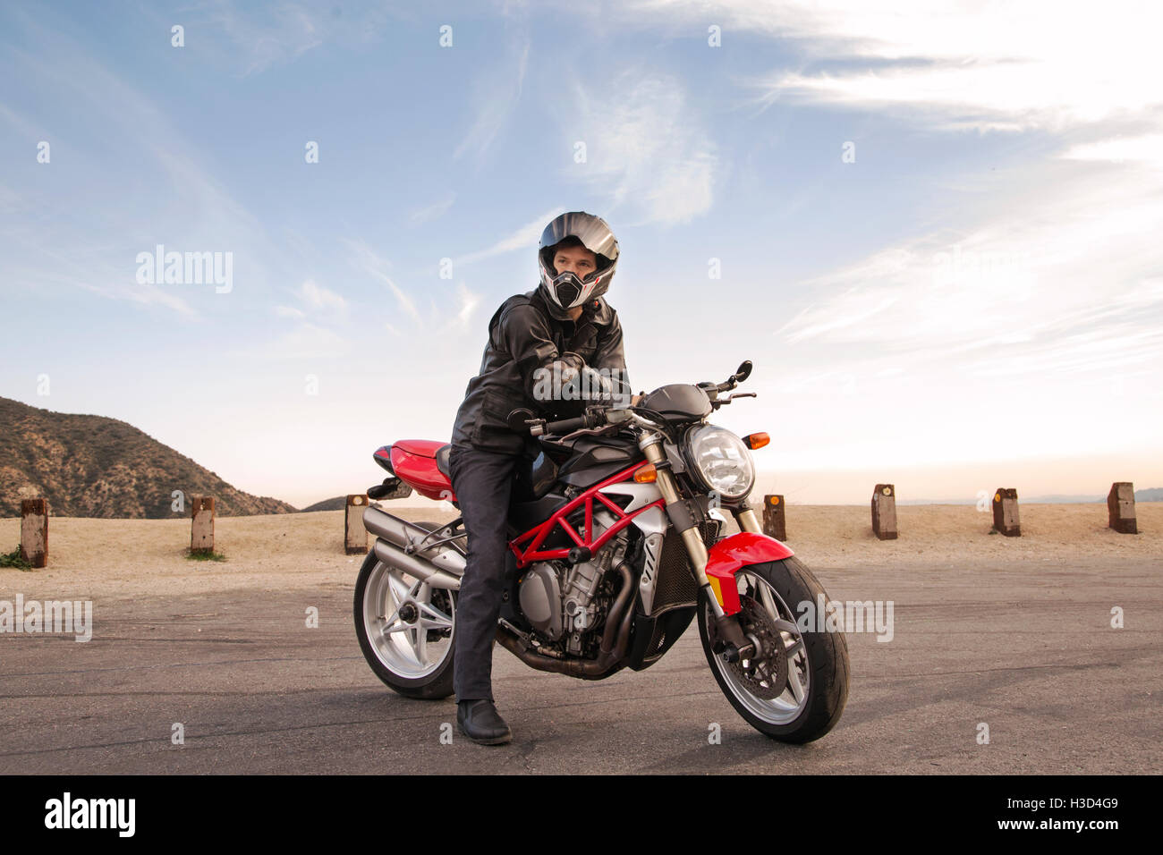 Ritratto di Biker seduto sul motociclo indossano il casco Foto Stock