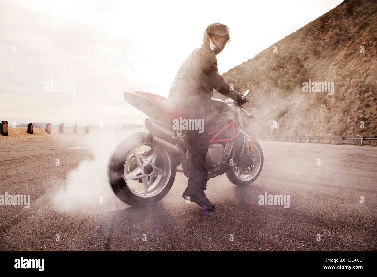 Biker filatura pneumatico posteriore del motociclo in lotto aperto Foto Stock