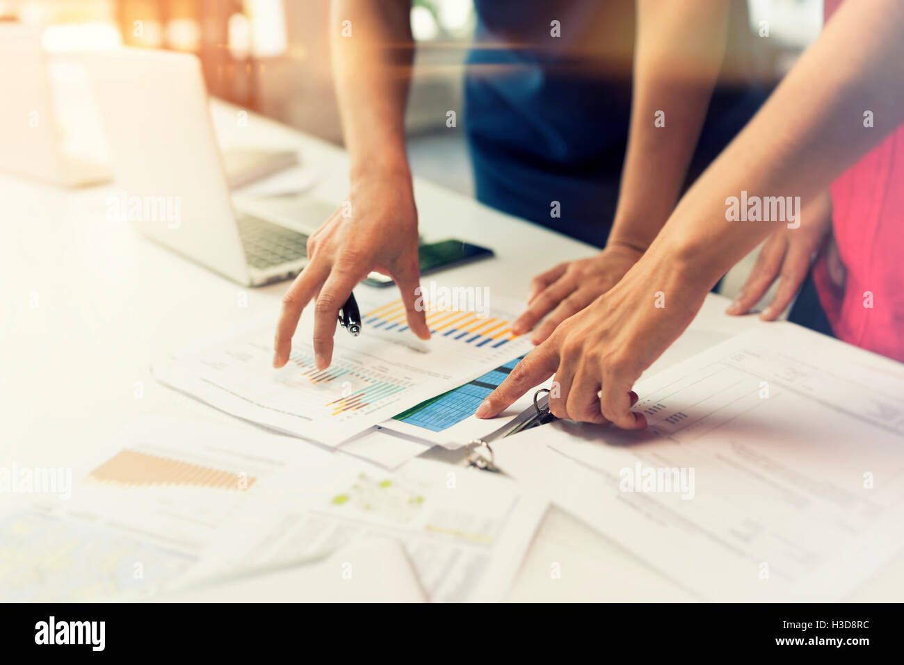 Due donne che lavorano insieme su dati grafici in carta. Ufficio di avvio Foto Stock