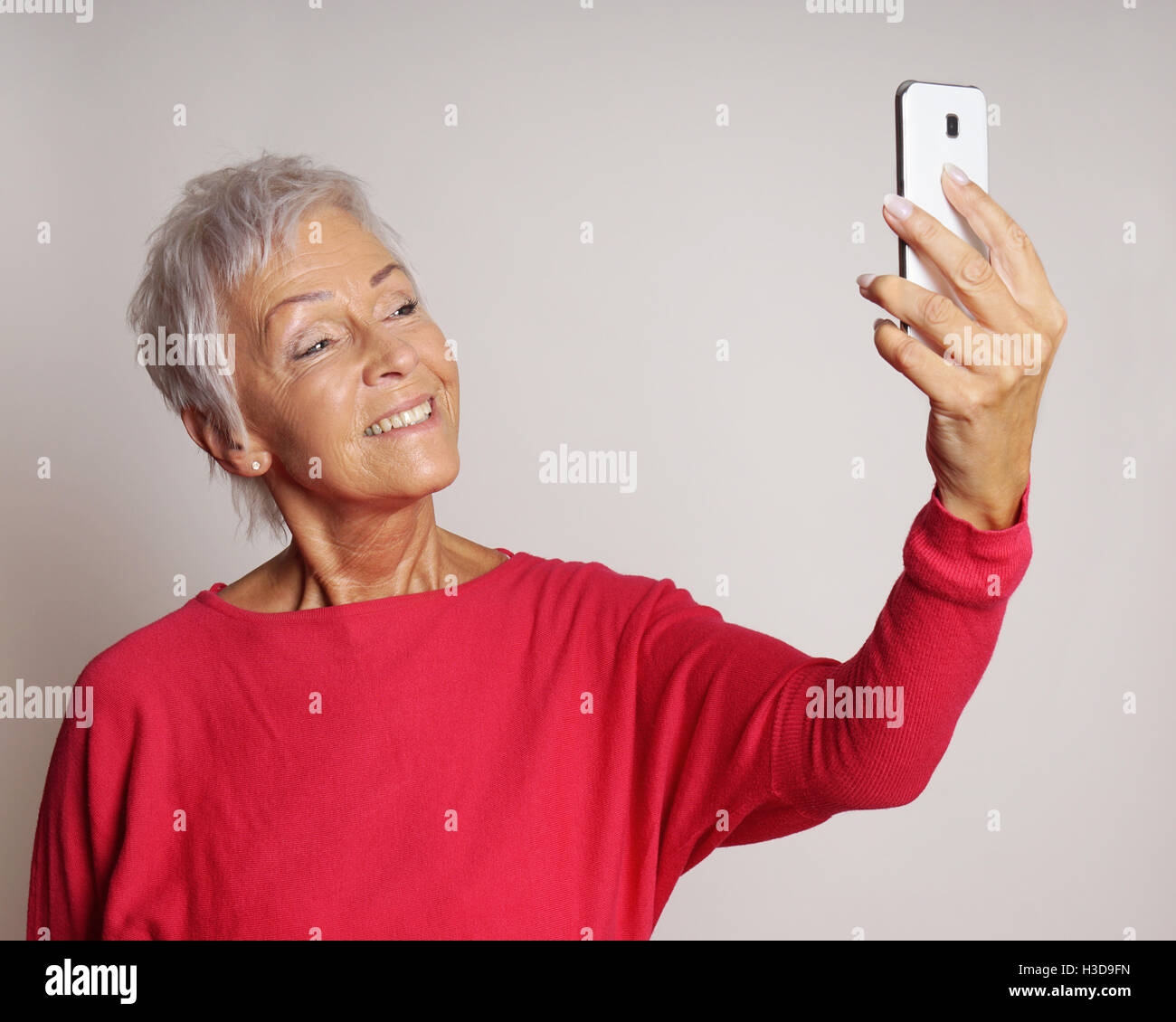 Donna matura prendendo un selfie con lo smartphone Foto Stock
