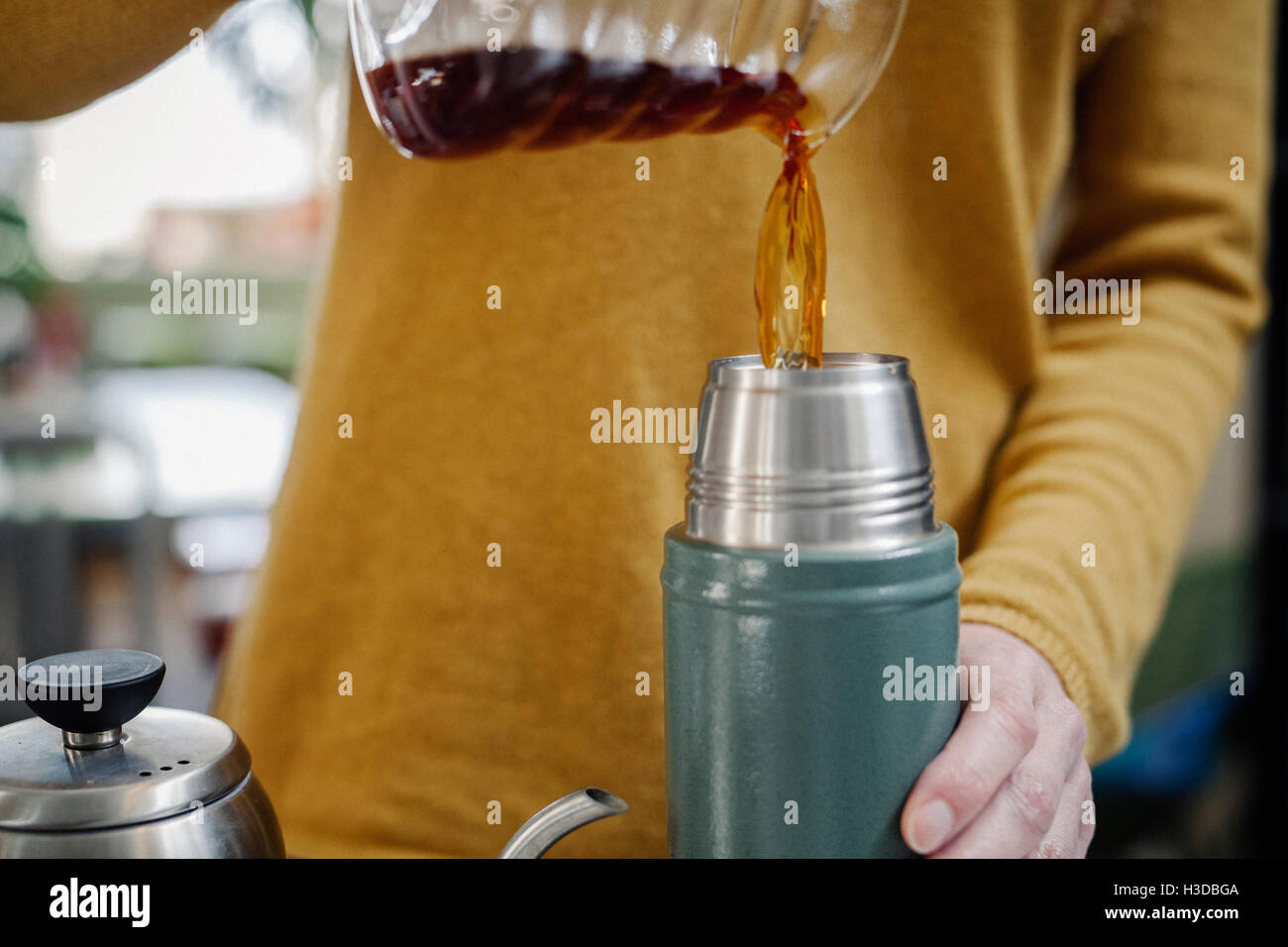 Una donna versando il caffè in un pallone. Foto Stock