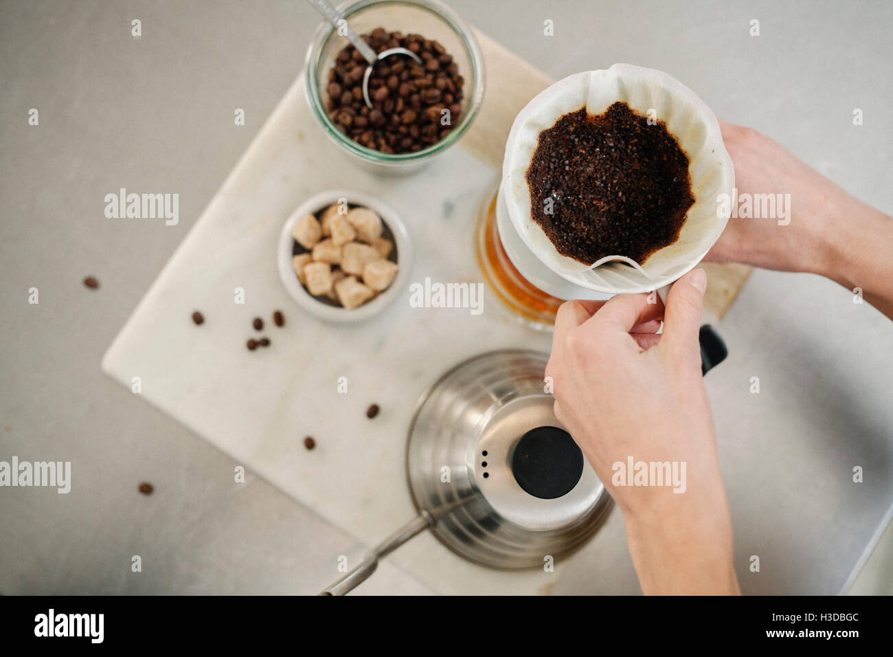 Il caffè macinato, filtro di carta e zollette di zucchero. Foto Stock