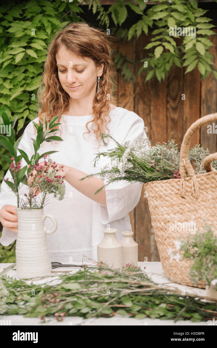 Una donna di preparare una miscela di erbe per cucinare, la scomposizione della lascia fuori per la trinciatura. Foto Stock