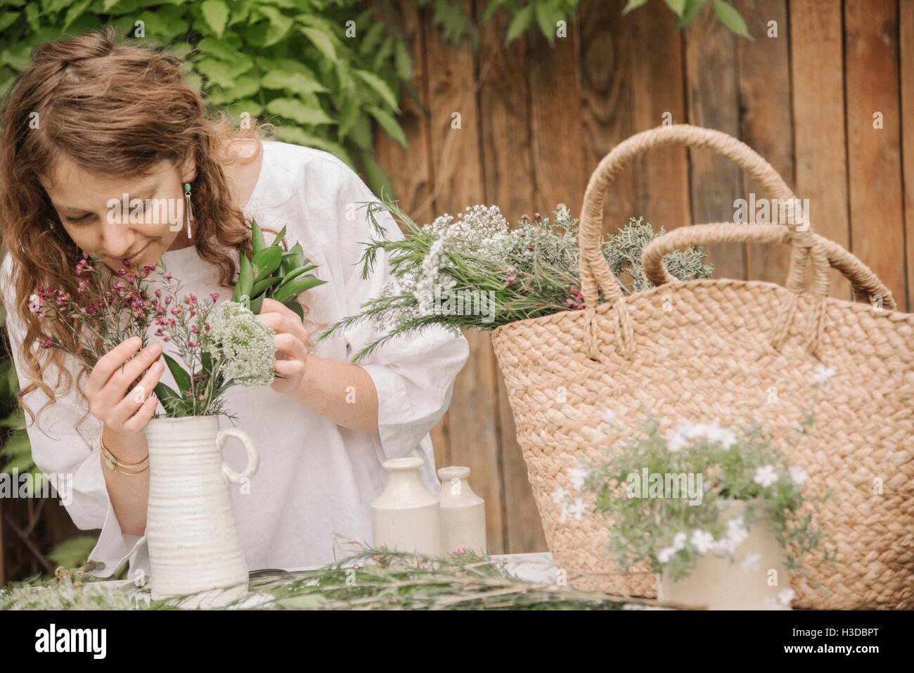 Una donna di preparare una miscela di erbe per cucinare, la scomposizione della lascia fuori per la trinciatura. Foto Stock