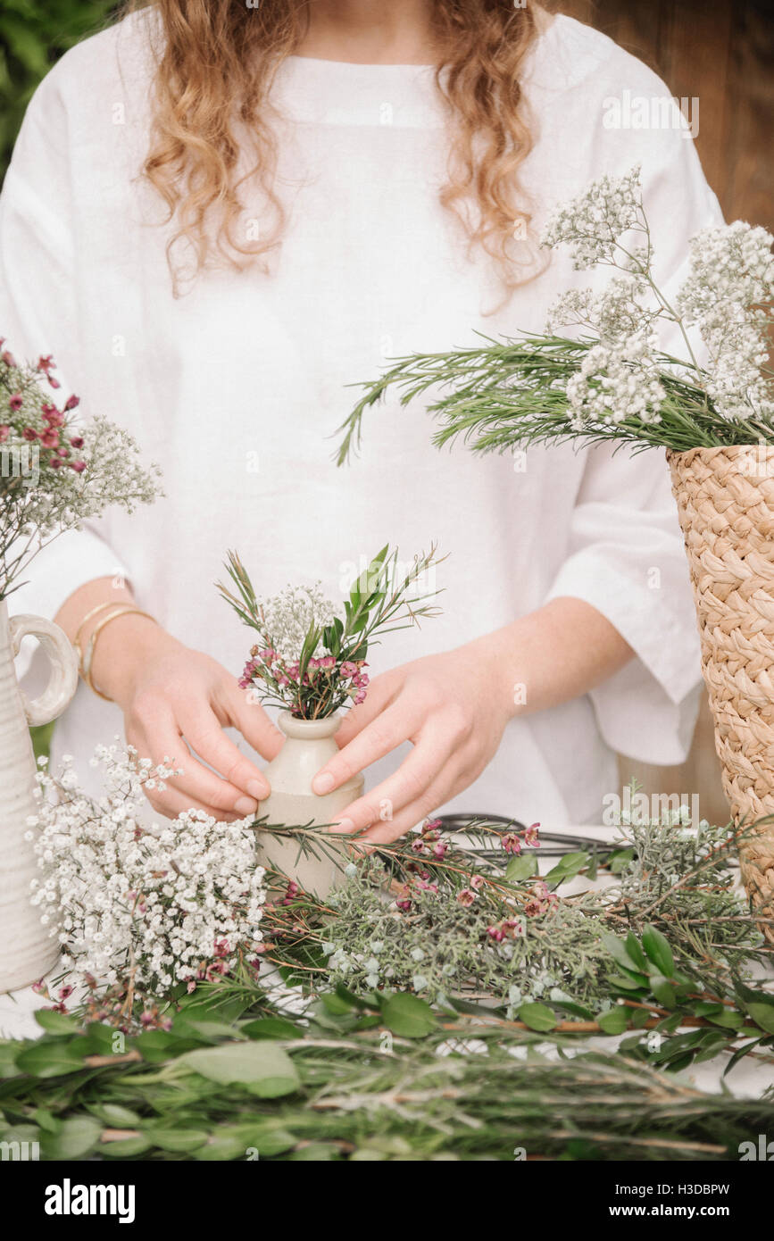 Una donna di preparare una miscela di erbe per cucinare, la scomposizione della lascia fuori per la trinciatura. Foto Stock