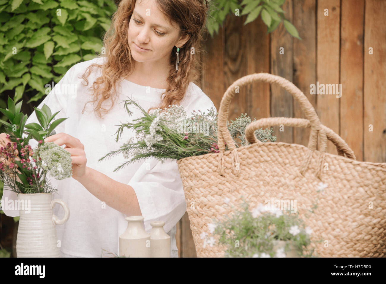 Una donna di preparare una miscela di erbe per cucinare, la scomposizione della lascia fuori per la trinciatura. Foto Stock
