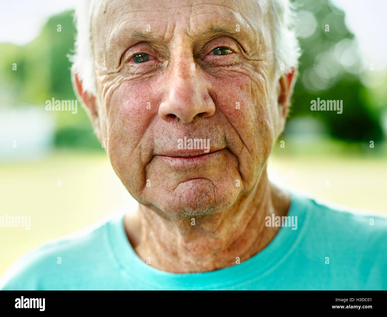 Ritratto di un uomo anziano con capelli grigi, sorridente alla fotocamera. Foto Stock