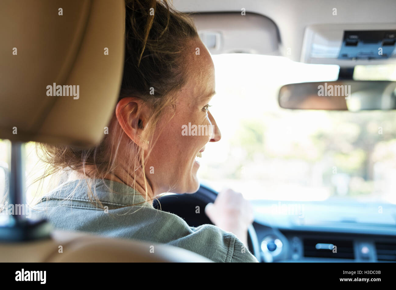 Donna matura con capelli biondi alla guida di una vettura. Foto Stock