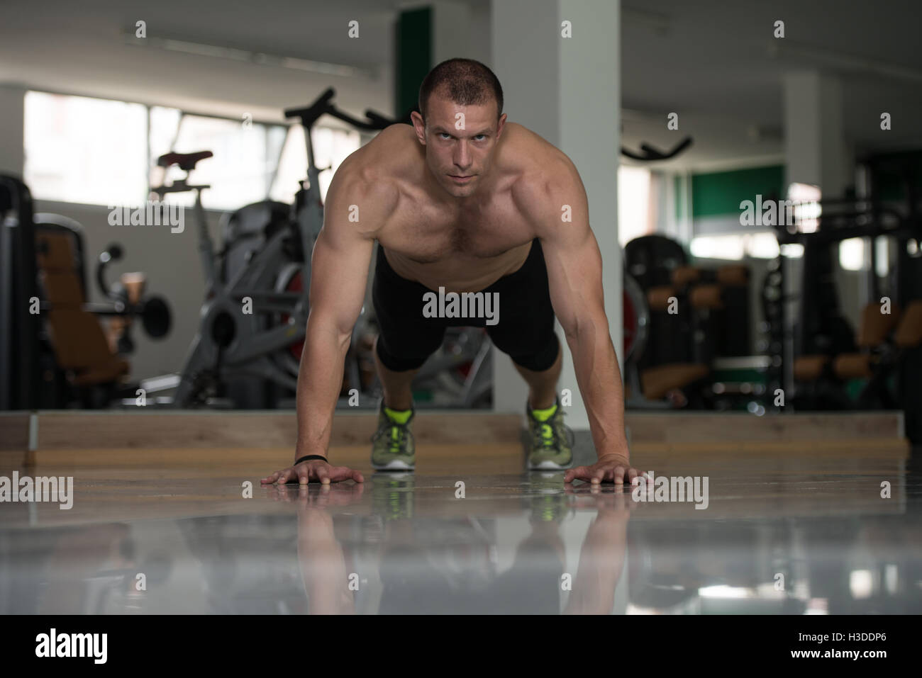 Uomo sano atleta fa pushups come parte della formazione bodybuilding Foto Stock