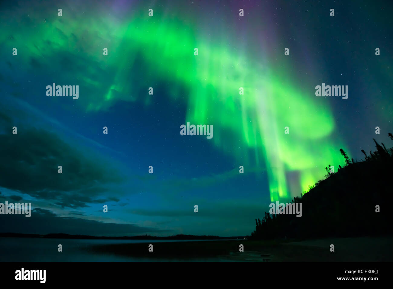 Aurora sul lago - nube luminosa-forma aurora boreale il fascio verso il basso su un lago dal cielo stellato. Foto Stock