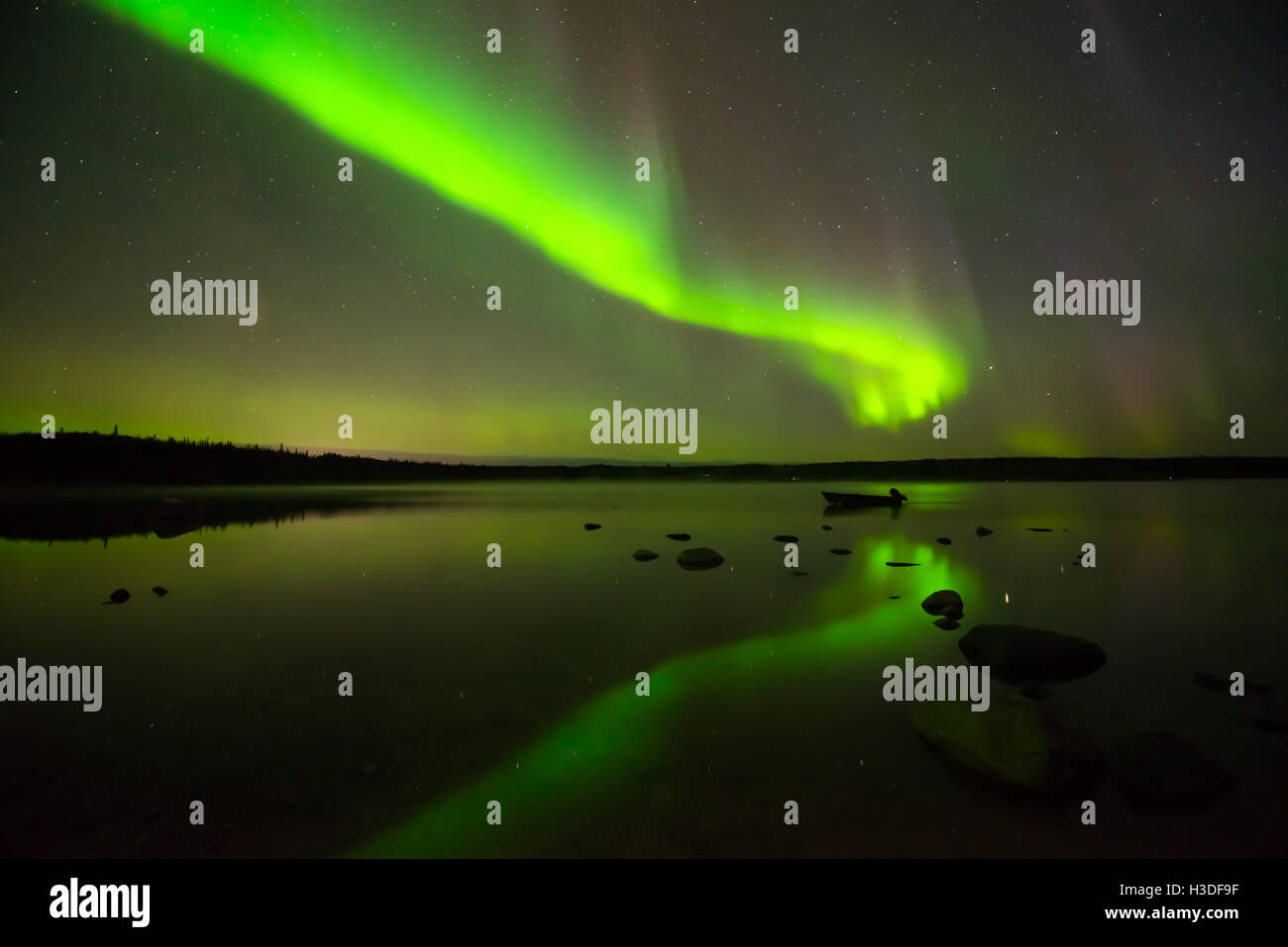 Aurora Boreale e cielo stellato - multi-colore aurora boreale luminose fino il cielo stellato sopra di un tranquillo lago. Foto Stock
