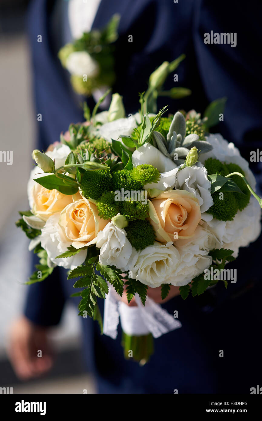 Lo sposo tenendo un bellissimo matrimonio bouquet di rose Foto Stock