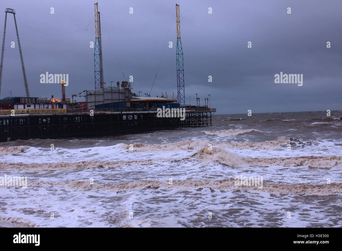 Una foto scattata in Blackpool che mostra la instabile e onde potenti, con la fiera in background. Foto Stock