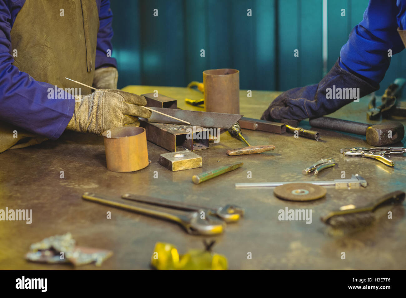 Sezione intermedia di maschio e femmina saldatrici lavorando insieme Foto Stock