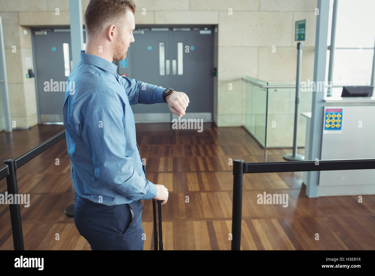 Uomo in piedi con i bagagli tempo di controllo Foto Stock