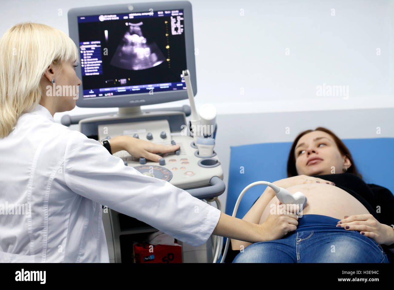 La gravidanza di una ragazza facendo su esame a ultrasuoni Foto Stock