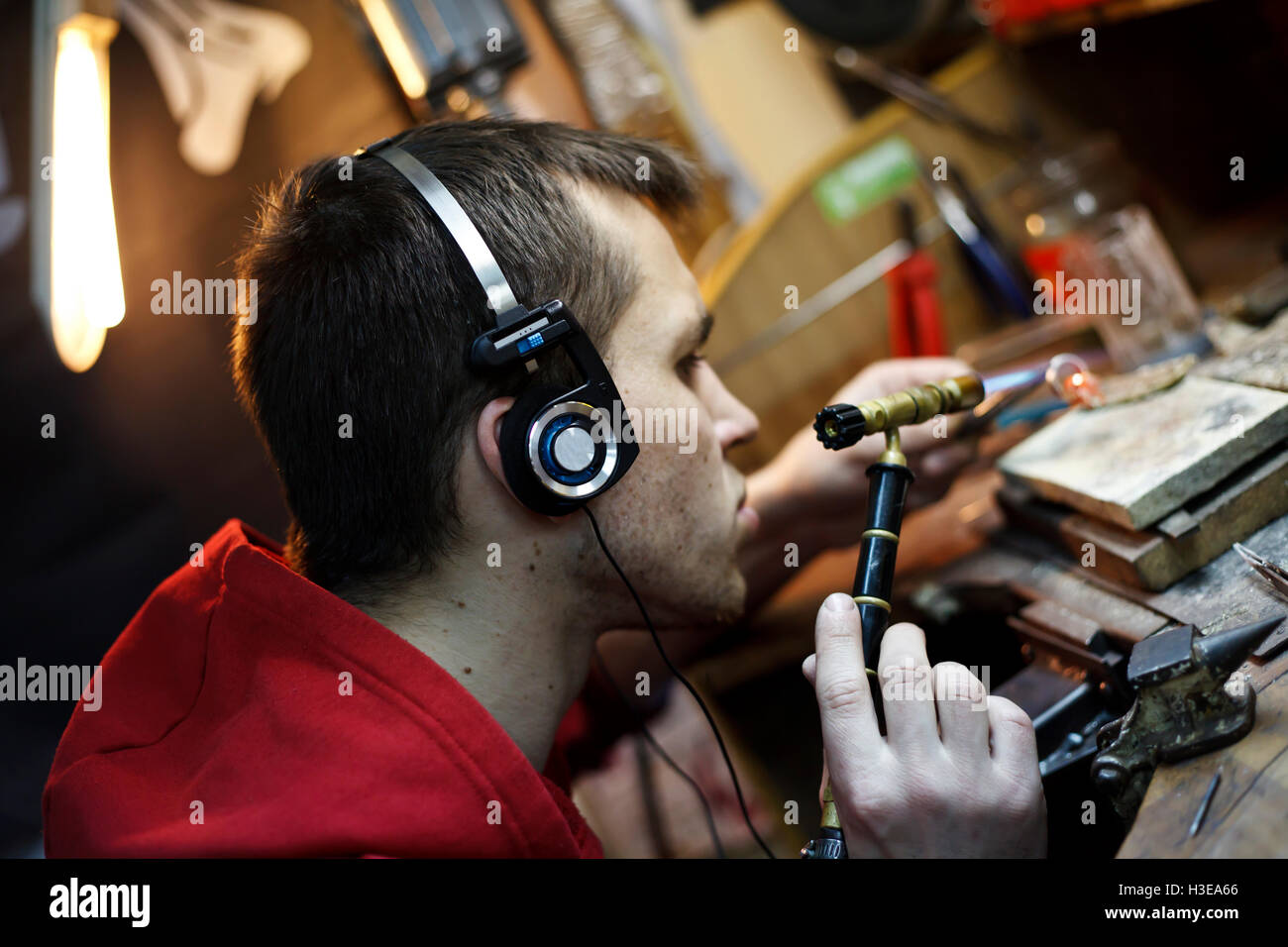 Un gioielliere dietro una scrivania prodotto a saldare Foto Stock